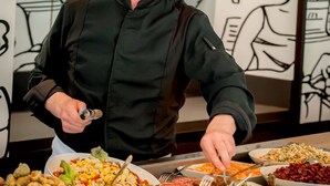 A chef serving food at a buffet with various dishes on plates. - ibis Quimper (Quimper)