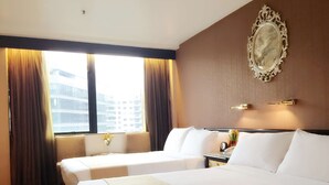 A hotel room with two beds, a large window with curtains, a wall-mounted mirror, and a small table with a vase of flowers. - Best Western Plus Tsim Sha Tsui (Kowloon)