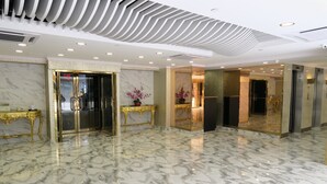 A lobby with marble flooring, gold accents, and modern ceiling design. - Best Western Plus Tsim Sha Tsui (Kowloon)