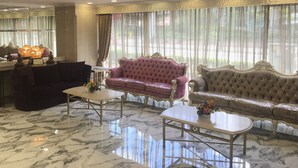 A luxurious room with a plush purple sofa, a matching armchair, and a marble floor. - Best Western Plus Tsim Sha Tsui (Kowloon)