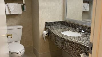 Une salle de bain équipée de toilettes, d’un lavabo et d’un porte-serviettes.