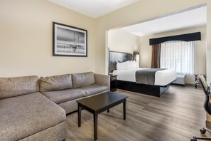 A hotel room with a large bed, a sofa, a small table, and a framed picture on the wall. - Best Western Bar Harbour Inn (Massapequa Park)