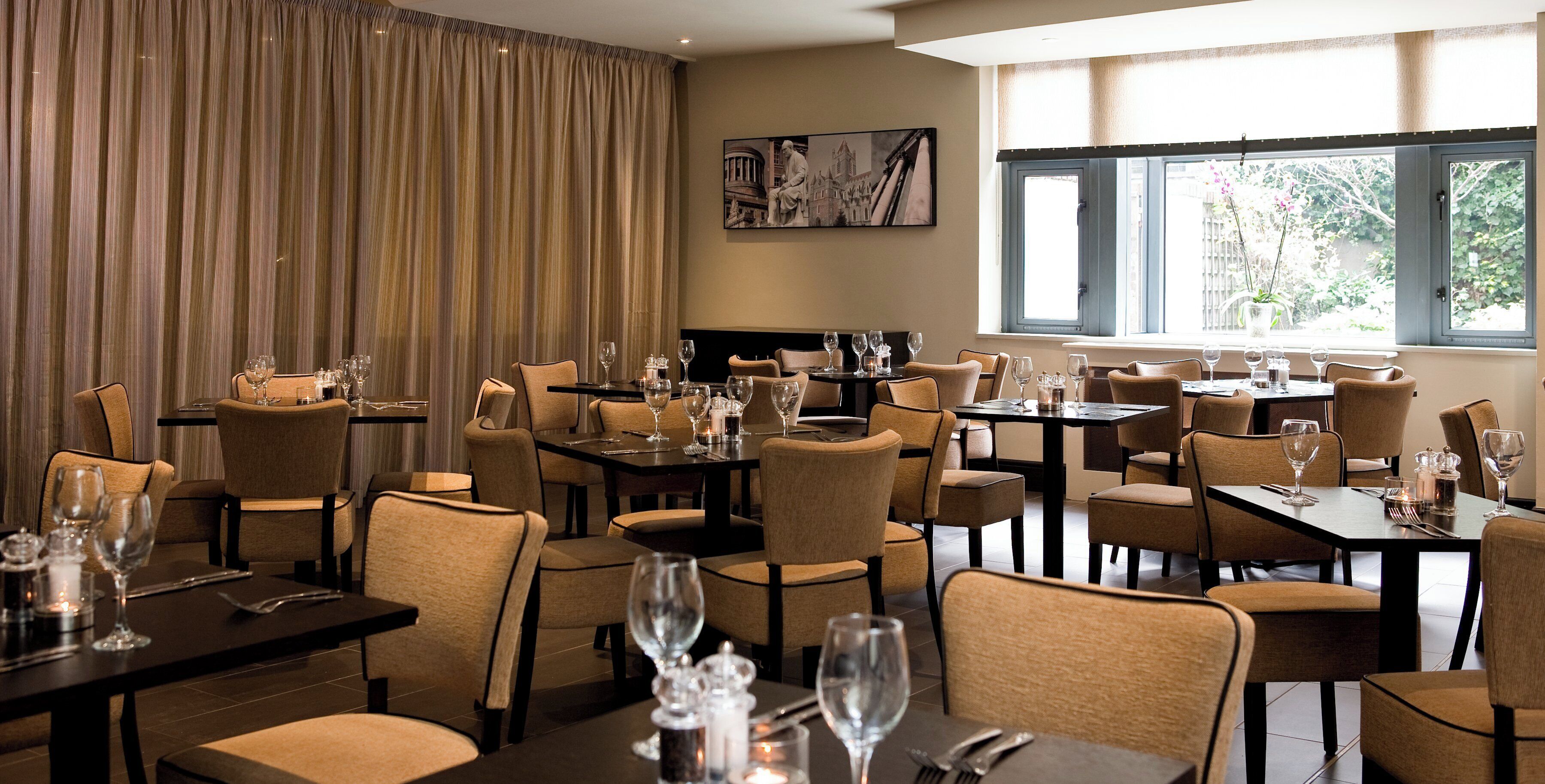 A restaurant with multiple tables and chairs, arranged in a spacious layout.