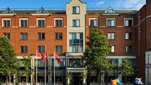 Een hotel met een gevel van baksteen, meerdere ramen en een opvallende ingang.