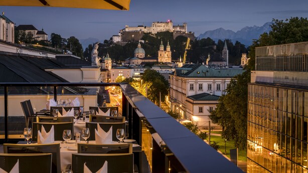 A restaurant with tables set for dining, overlooking a historic castle and cityscape. - IMLAUER Hotel Pitter Salzburg (Salzburg)