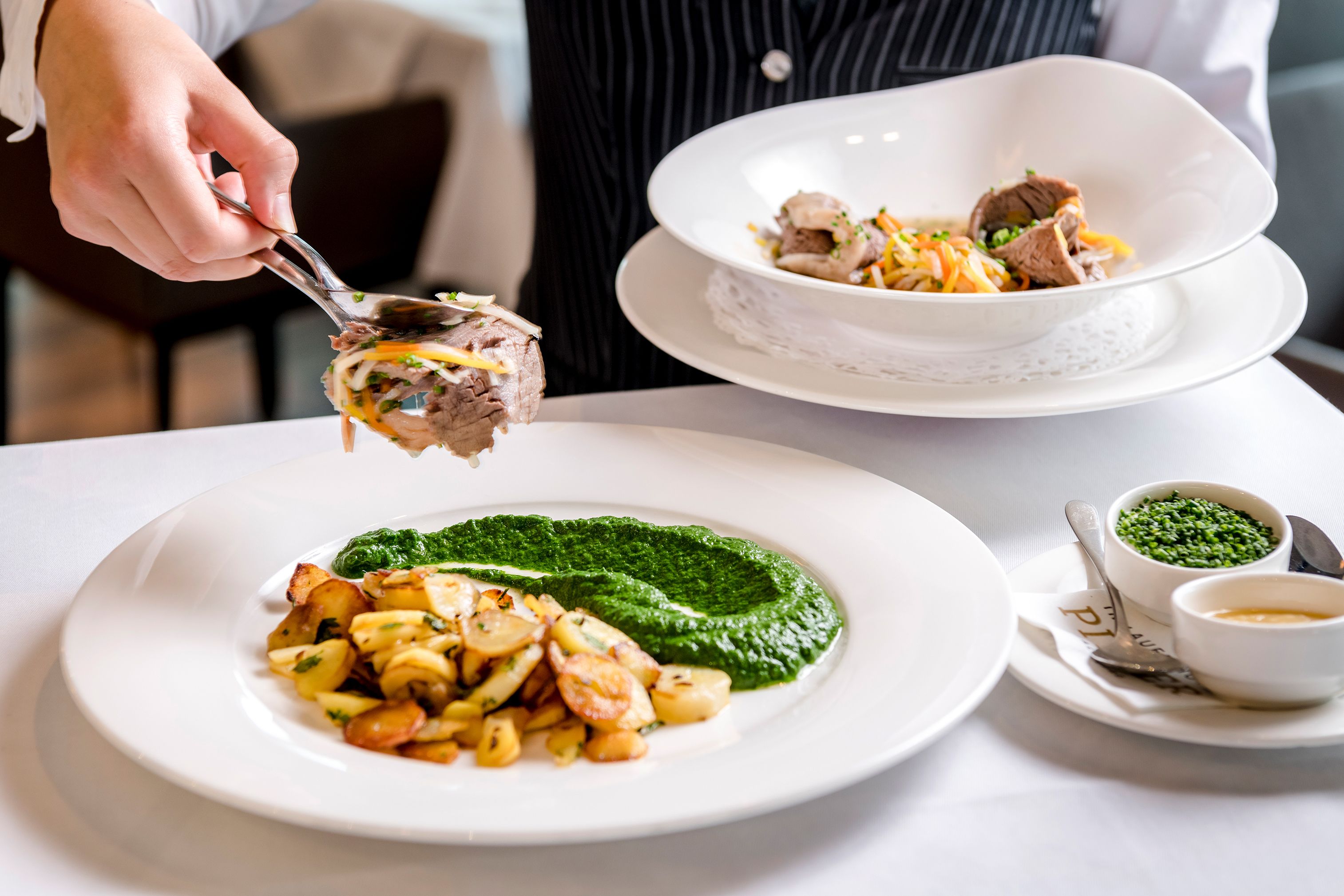 A person serving food from a bowl onto a plate.