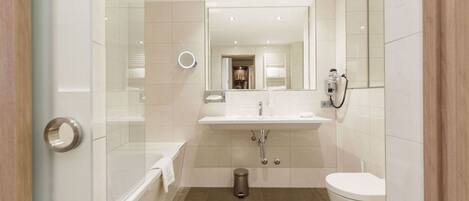 A modern bathroom with a glass shower enclosure, a white sink, a toilet, and a mirror.