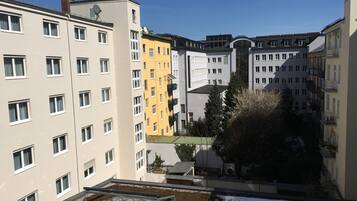 A multi-story residential building with a courtyard featuring a circular water feature and a small garden area.