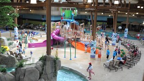 An indoor water park with multiple water slides, a pool, and lounge areas. - Soaring Eagle Waterpark and Hotel (Mount Pleasant)