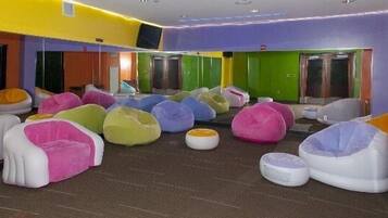A room with colorful bean bags and a green door.