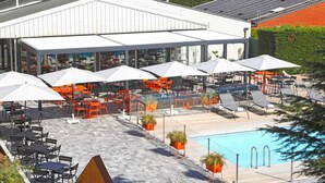 A rooftop pool area with outdoor seating and a wooden structure. - ibis Styles Nancy Sud (Houdemont)