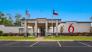 Welcome to our hotel, featuring a prominent entrance with a covered walkway and beautifully maintained grounds.