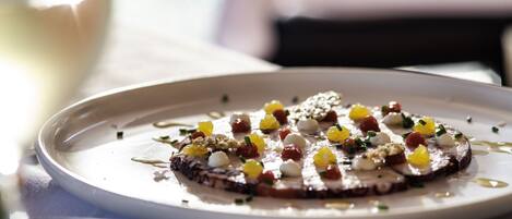 Un plato con un guiso, posiblemente pizza o tarta, adornado con diversos ingredientes.