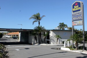 Señal de Best Western con vista clara de la entrada, palmeras y un estacionamiento.