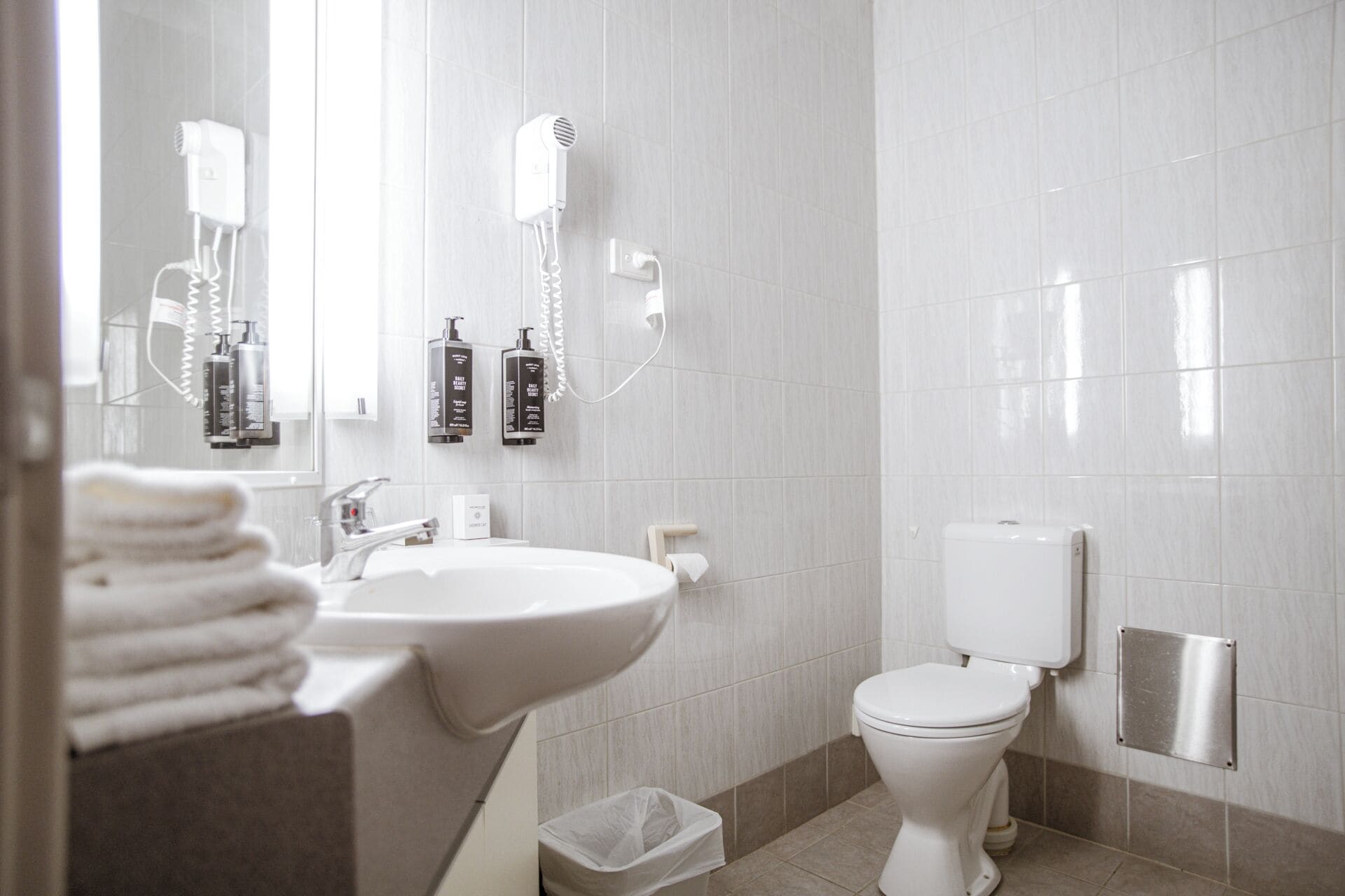 A modern bathroom with a sink, toilet, and hairdryer.