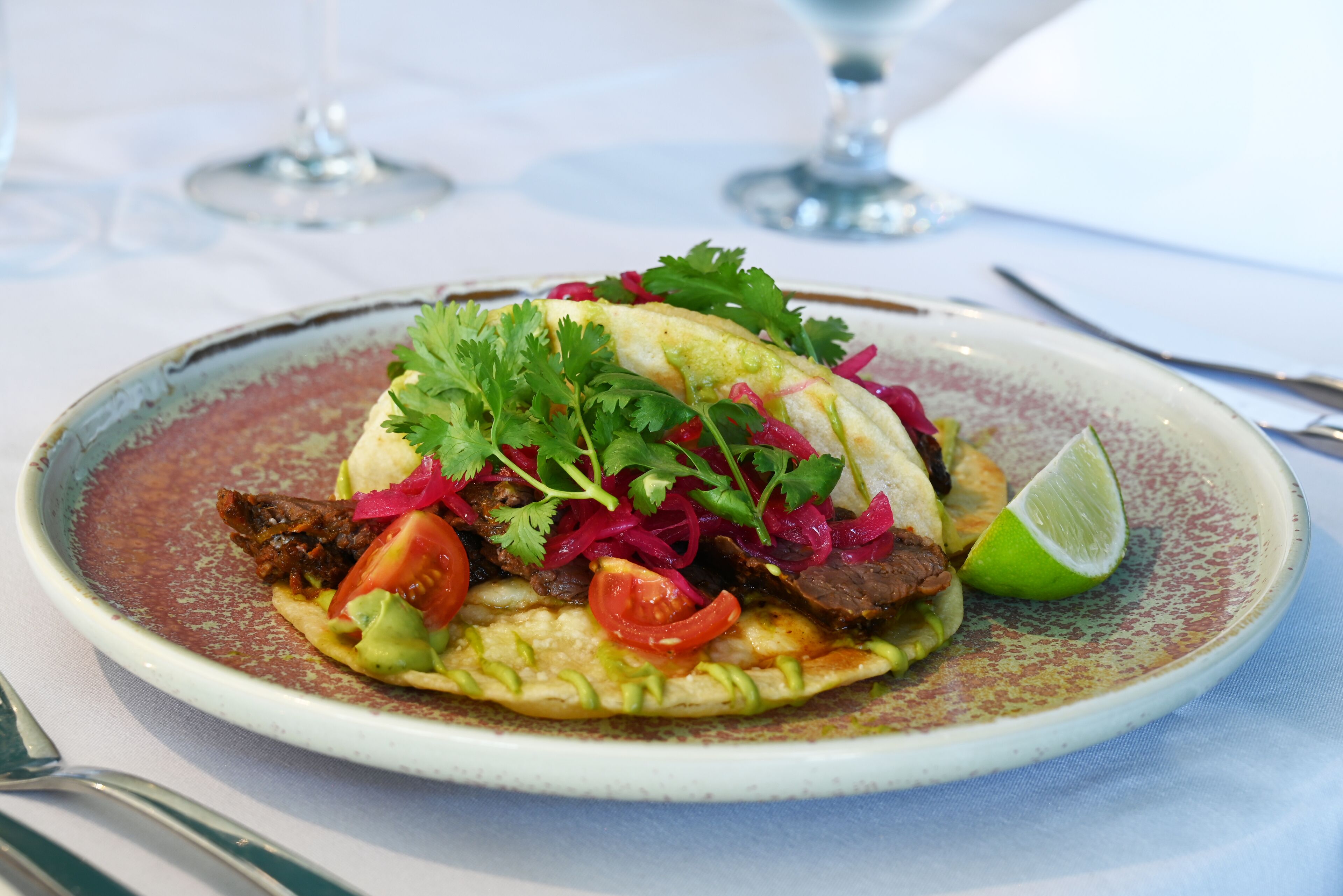 A plate of food with a lime wedge on the side.