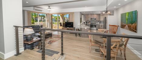 Un espacio habitable moderno y abierto, con cocina, comedor y balcón con vistas.
