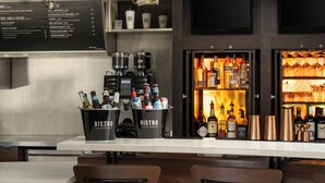 A bar area with a menu board, a minibar, and a well-stocked bar shelf. - Courtyard by Marriott Hartford Cromwell (Cromwell)