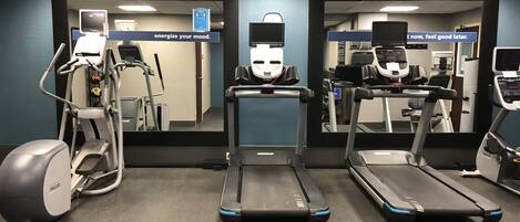 A gym with treadmills, an elliptical, and a stationary bike.