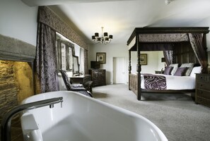 A bedroom with a four-poster bed, a large bathtub, and a chandelier. - Boringdon Hall Hotel and Spa (Plymouth)