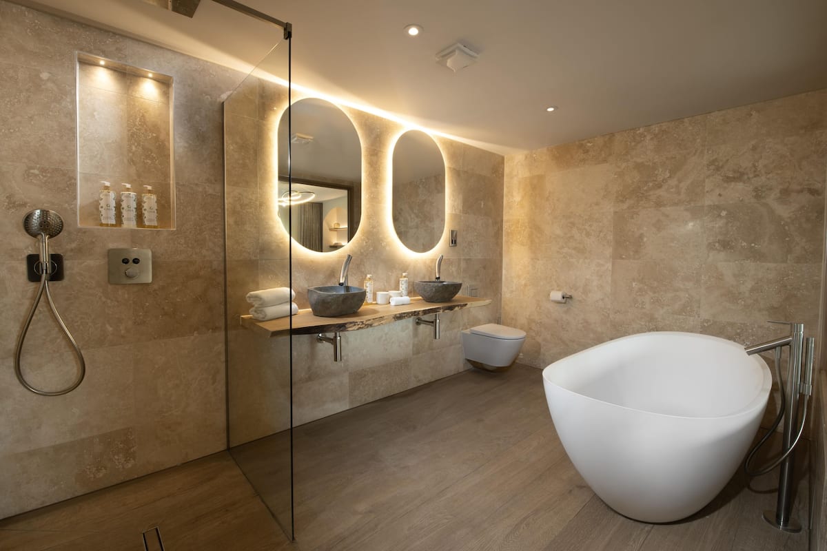 deluxe studio suite | bathroom | separate bathtub and shower, deep-soaking bathtub, designer toiletries