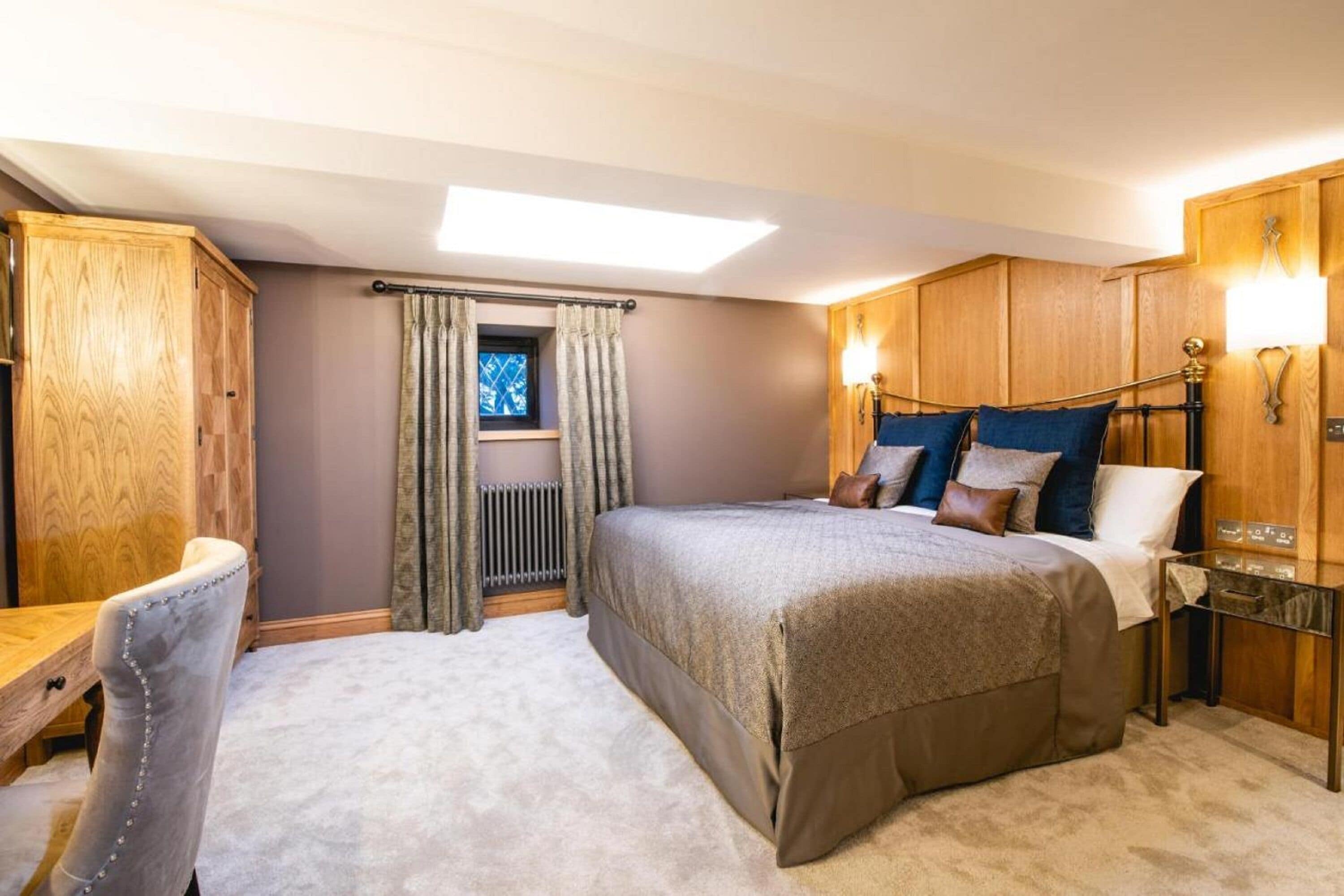 A bedroom with a bed, a desk, and a wardrobe.