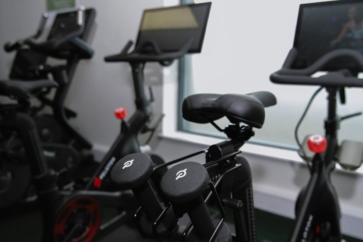 Stationary exercise bikes with digital screens and handlebars.