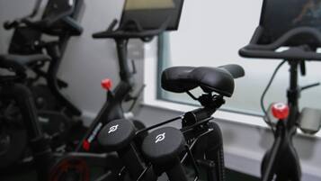 Stationary exercise bikes with digital screens and handlebars.