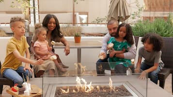 Enjoy a cozy evening by the fire pit, surrounded by comfortable seating and a casual dining area.