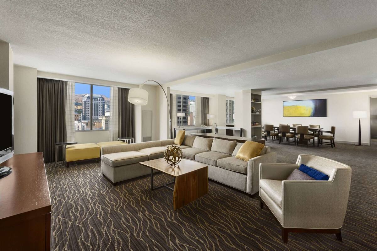 Une chambre d’hôtel comprenant un grand canapé, un coin repas et un téléviseur.