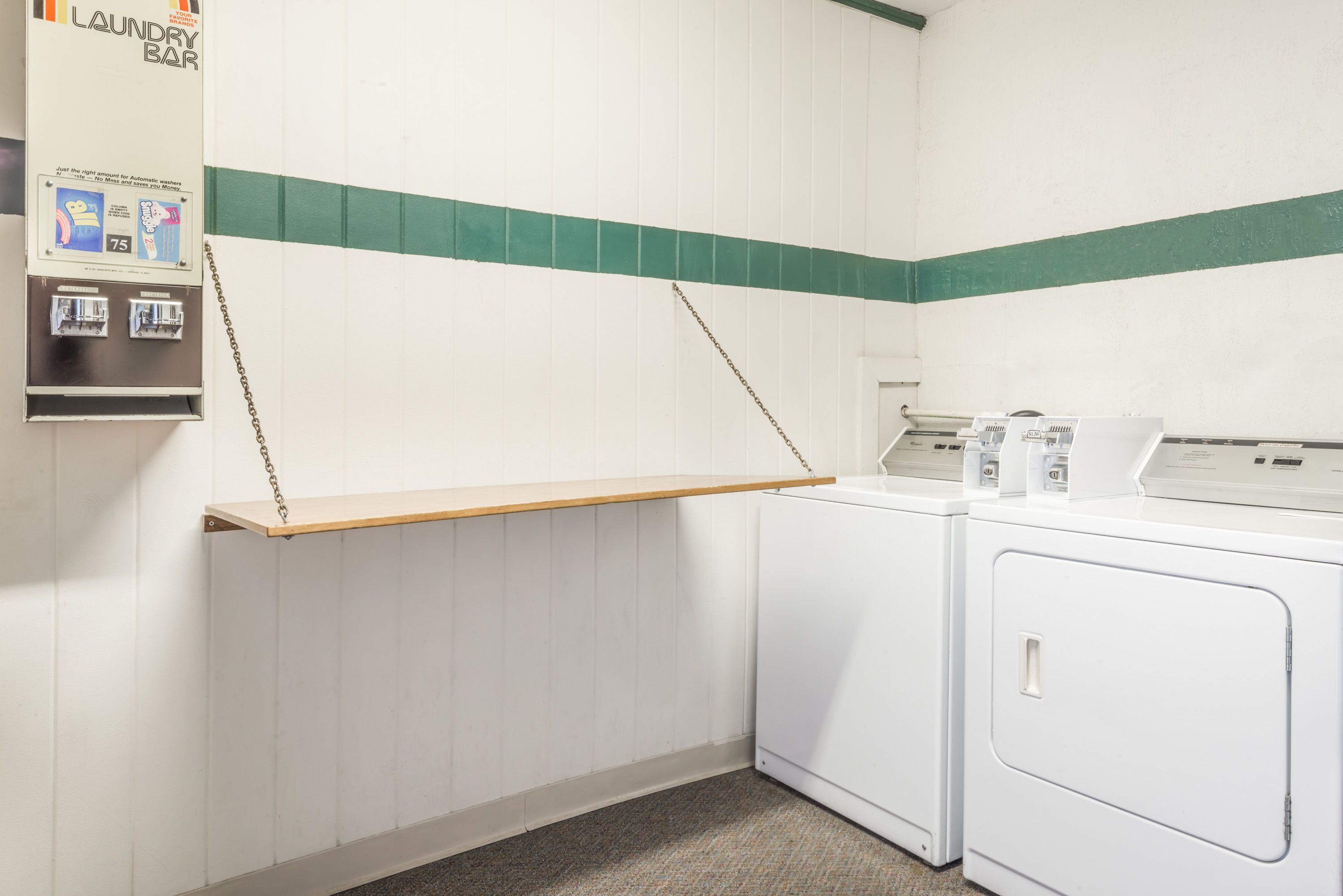 Una sala de lavandería con barra, lavadoras y un tendedero.