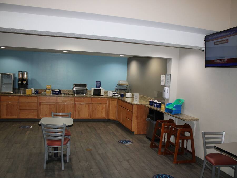 A kitchen area with wooden cabinets, a coffee machine, and a counter with various items.