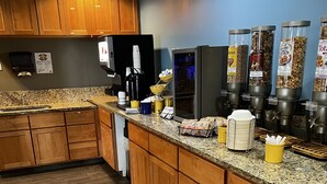 Een moderne keuken met houten kastjes, granieten aanrecht en een koffiehoek.