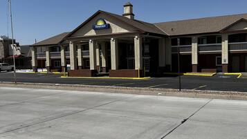 A Days Inn with a two-story structure, a covered front porch, and a parking lot in front.