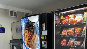 Een automaat met een Pepsi-reclame en diverse snacks.