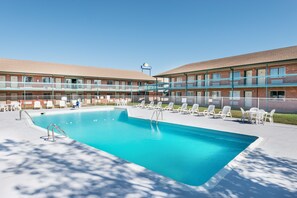 Piscine extérieure en saison, chaises longues