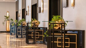 A modern lobby with glass-top tables, black and gold decor, and potted plants. - Steigenberger Hotel Bad Homburg (Bad Homburg v.d. Hoehe)