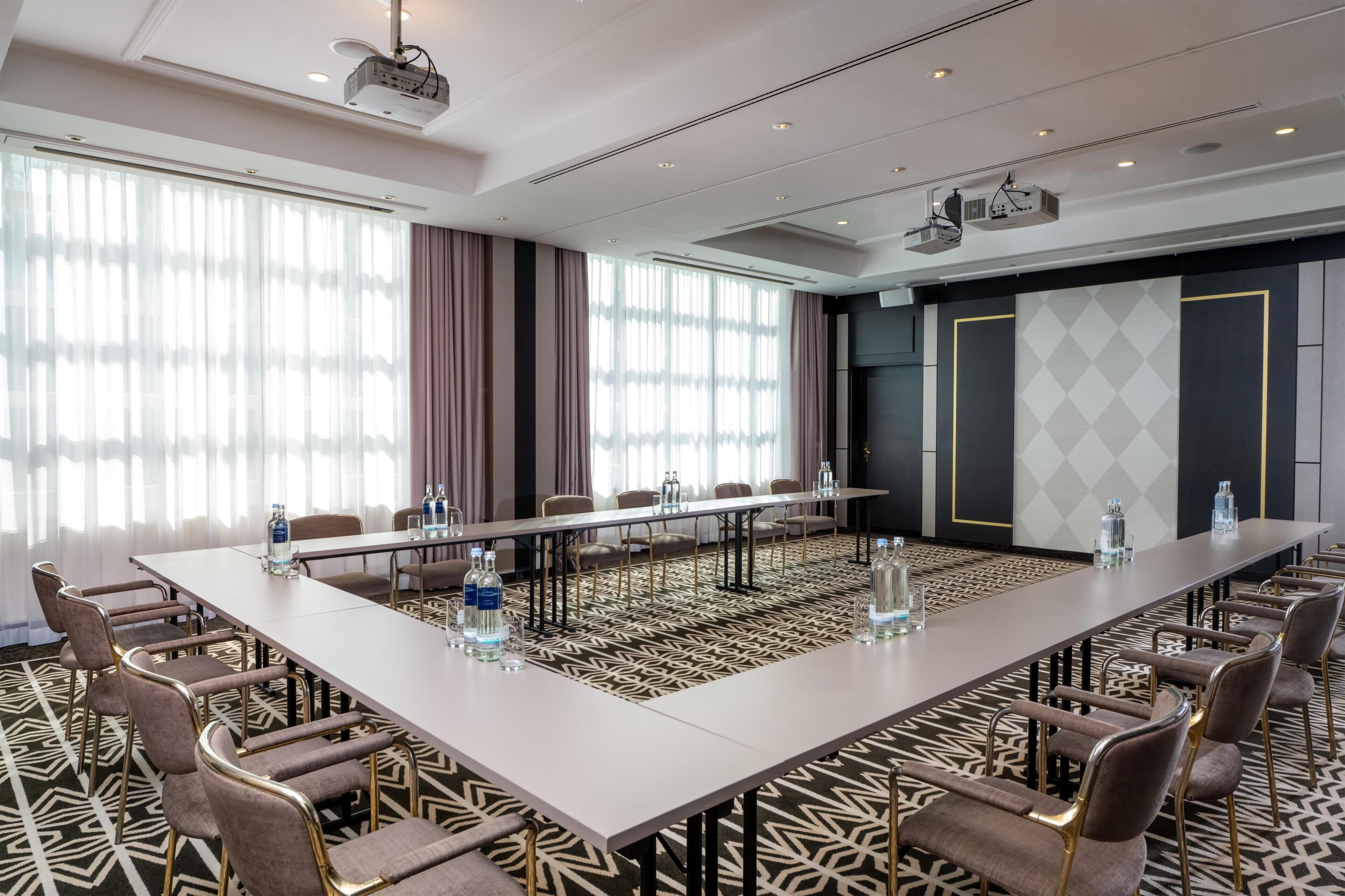A conference room with a long table, chairs, and water bottles.