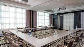 A conference room with a long table, chairs, and water bottles.