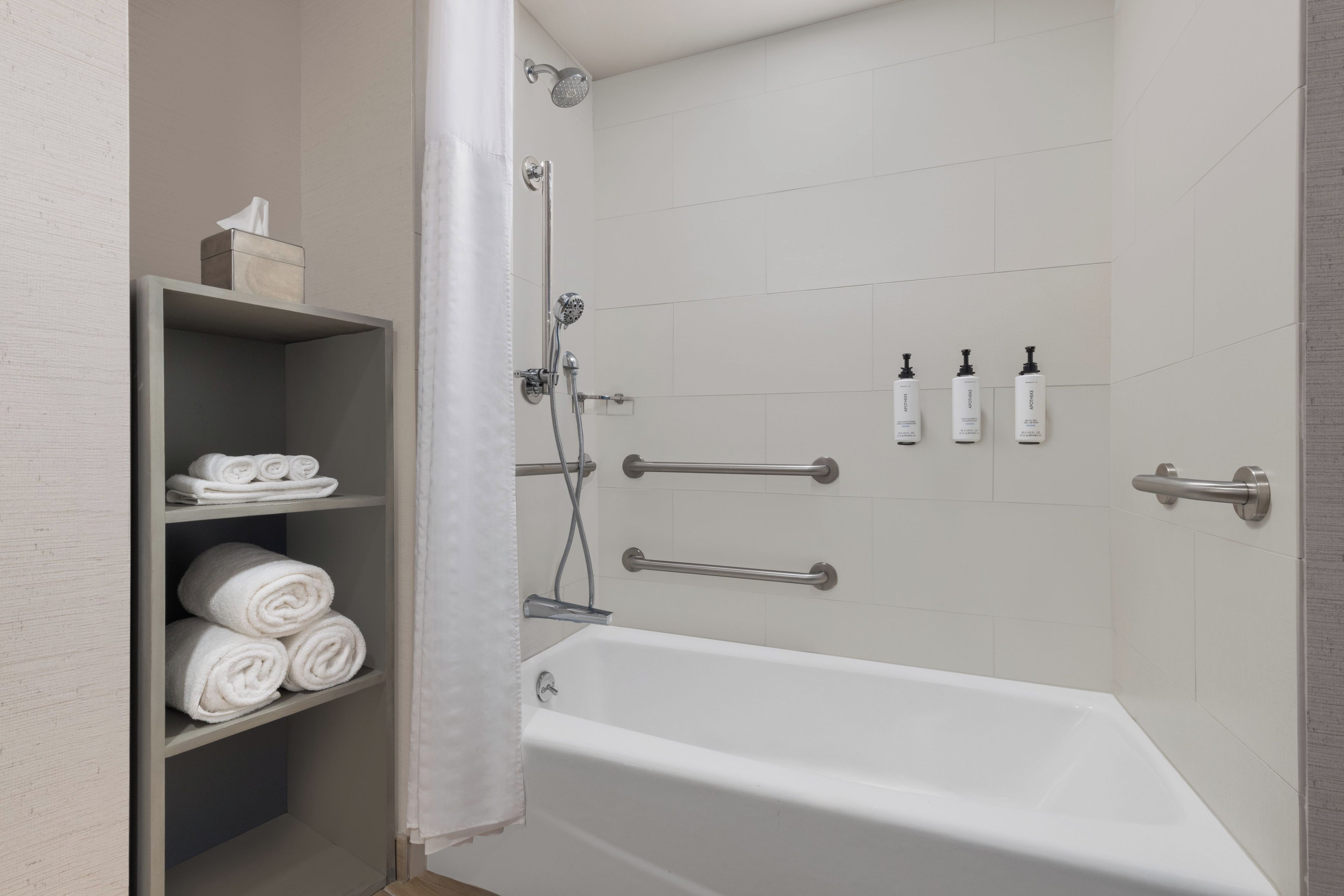 Un baño moderno con bañera, ducha y un estante con toallas.