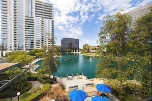 A view of a water feature surrounded by greenery and modern buildings.