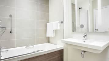 A modern bathroom with a bathtub, a sink, and a mirror.