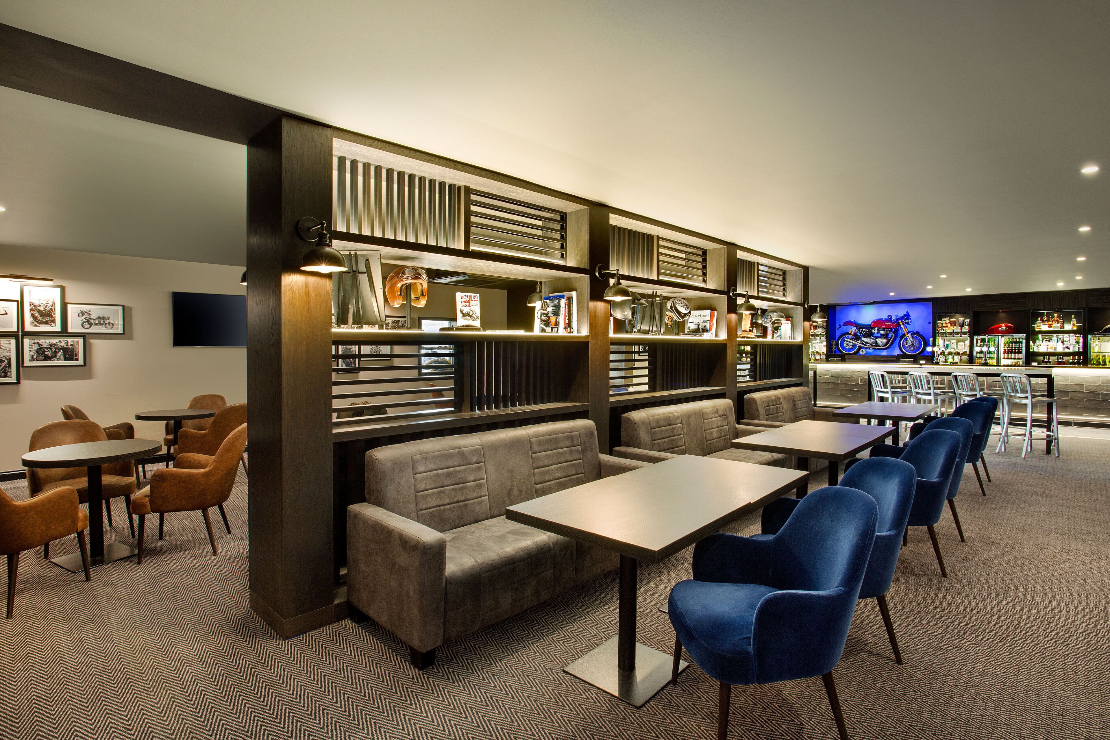 Ett modernt loungeområde med sittplatser, bord och en bar.