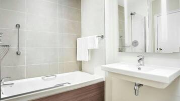 A modern bathroom with a bathtub, a sink, and a mirror.