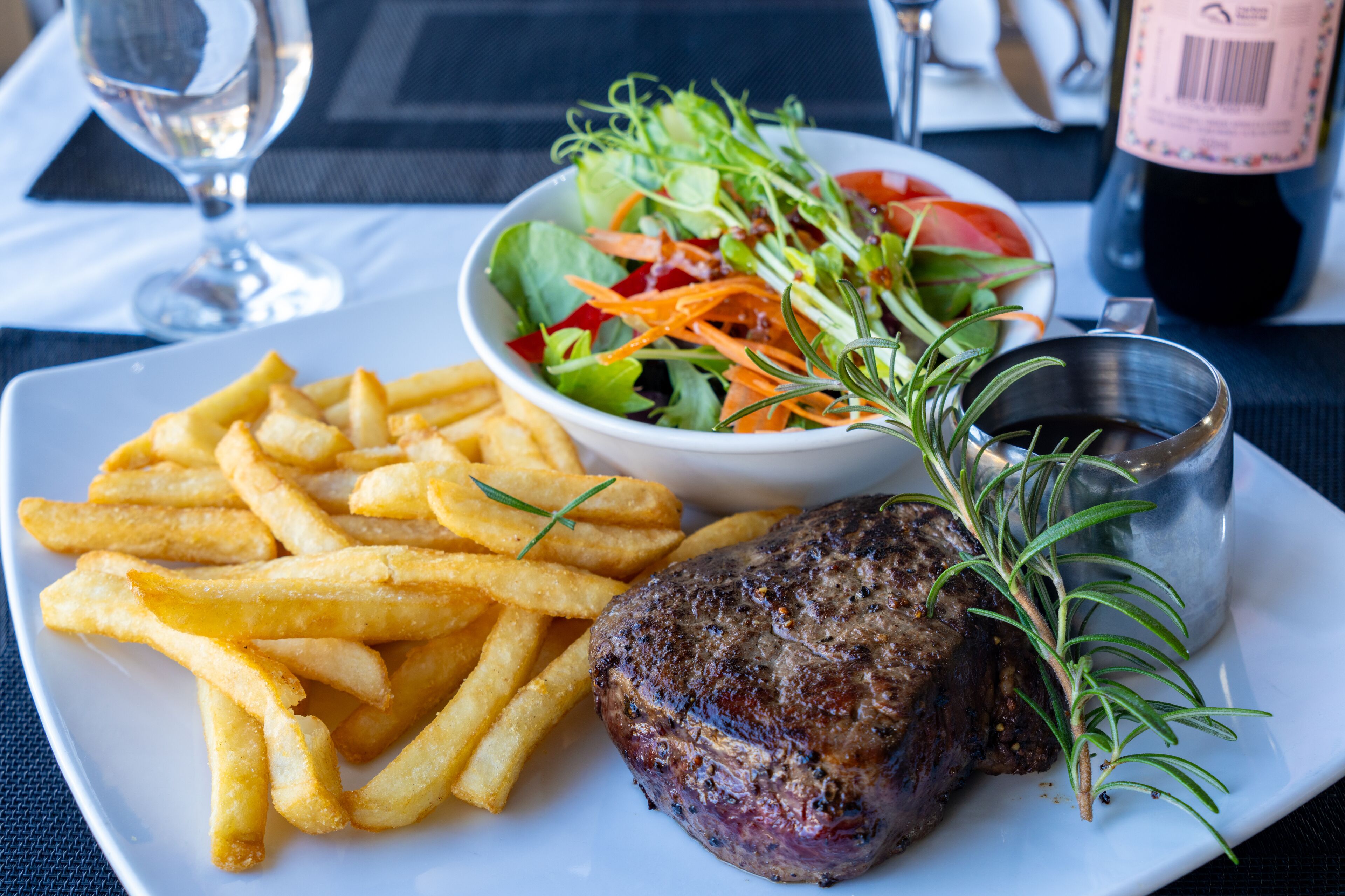 Ein Teller mit einem Steak, Pommes und einem Salat.