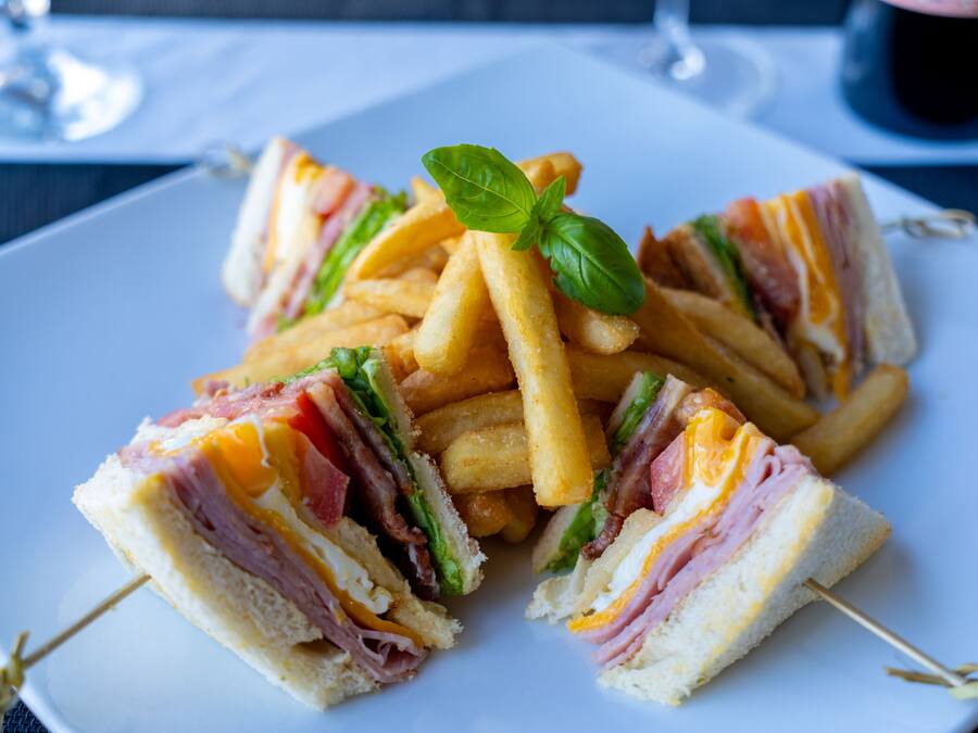 Um prato de sanduíches e batatas fritas.