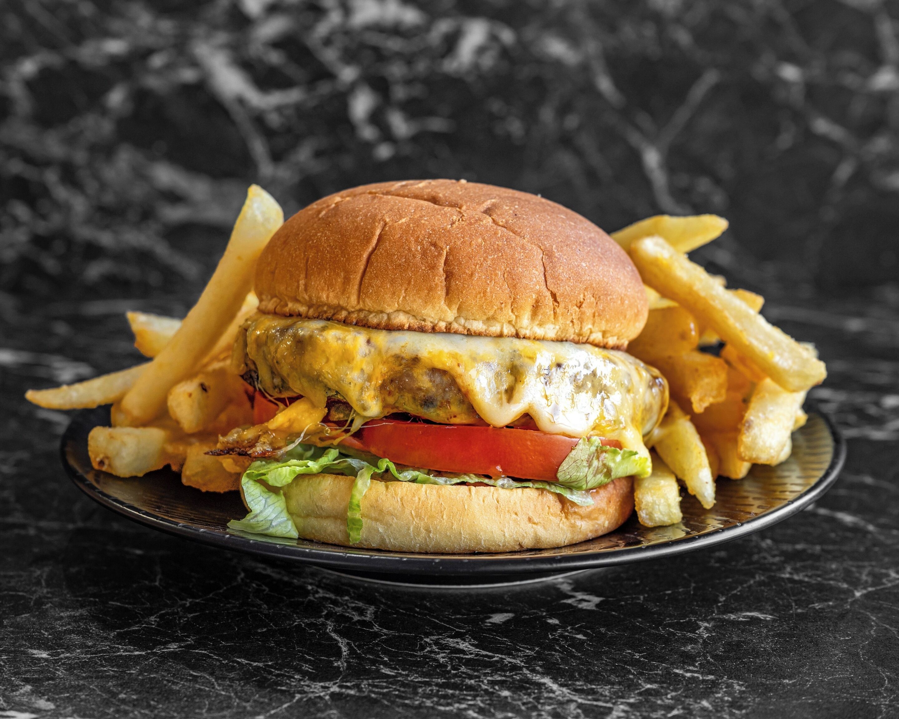 Una hamburguesa con papas fritas en un plato.