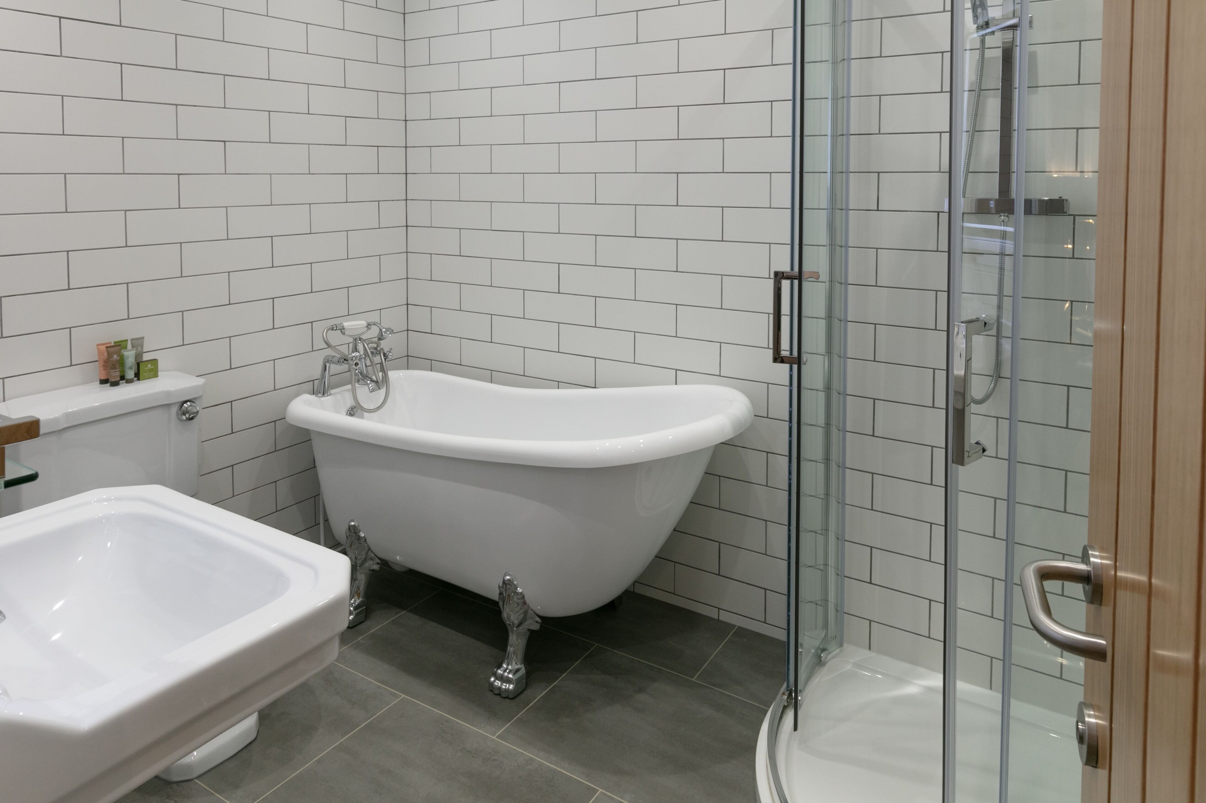 A modern bathroom with a freestanding bathtub, a glass-enclosed shower, and a separate sink.