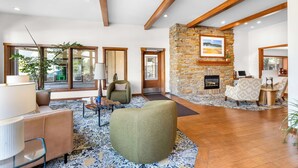 Amplia sala de estar con chimenea de piedra, ventanas grandes y muebles modernos.