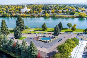 A large building with a swimming pool, surrounded by trees and a body of water. - Best Western Driftwood Inn (Idaho Falls)
